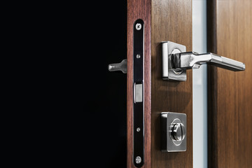 door handle and latch of brass on veneer doors. place for your text on a black background