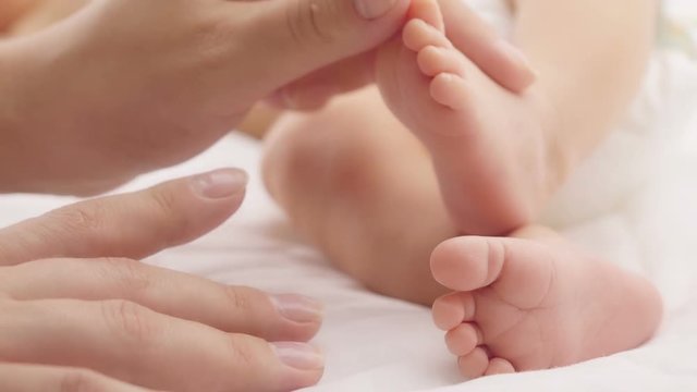 Baby feet in mother hands. Close up of little baby feet in hands of mother. 