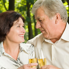 Senior couple celebrating with champagne, outdoors