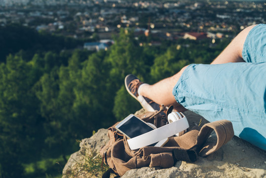 man sit on the ground of the peak hold phone in hands