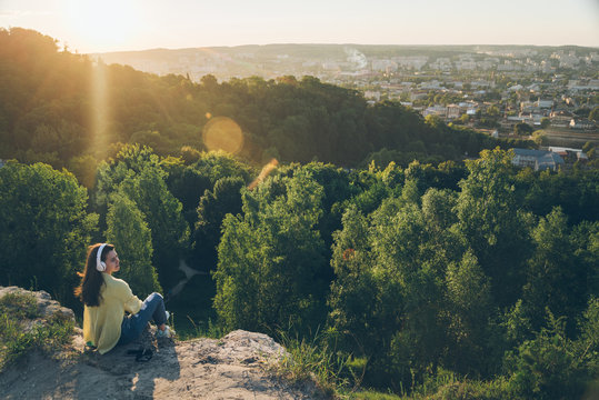 Young Pretty Woman Listing Music On The Top Of The Hill