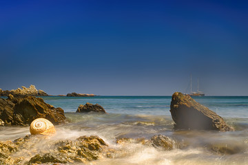 Fototapeta premium Lolantonis beach at Paros island. Long exposure with a seashell at the foreground. 