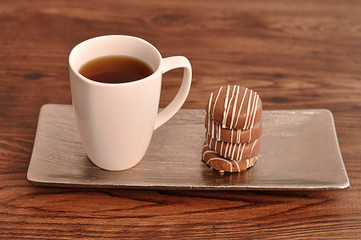 A stack of chocolate covered biscuits tied  and a  white mug