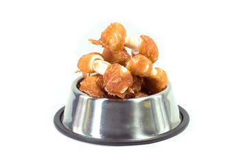 Chicken bone in stainless bowl for dog isolated on white. Snack for pets concept.