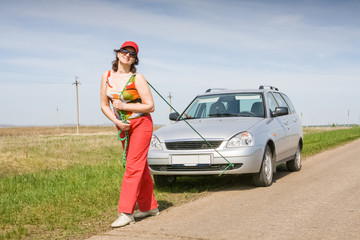 A woman is pulling a car in tow
