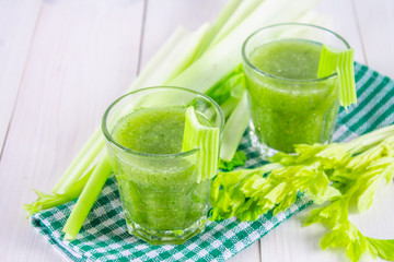 Vegetable cocktail made from celery leaves, healthy lifestyle on a white wooden background.