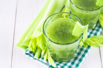 Vegetable cocktail made from celery leaves, healthy lifestyle on a white wooden background.