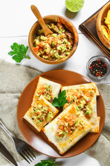 Traditional Mexican dish - chimichanga. Corn cake with minced meat, pepper, onion, garlic, oregano, zira and guacomole sauce from avocado.