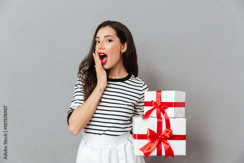 Sticker Portrait of a surprised woman holding stack of gift boxes