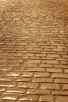Fototapeta Antique wet cobblestone street at dawn. Golden tone. Vintage background.