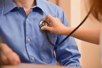 Female Doctor examining male patient.