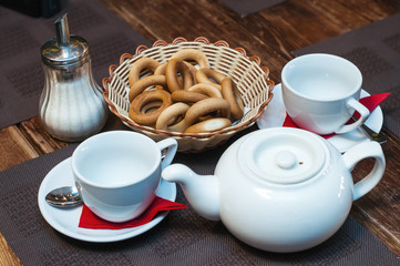 Drying, white cups and a teapot are on the table.