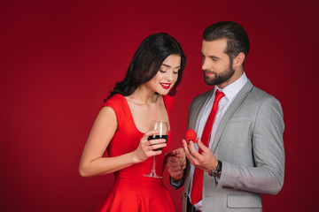 boyfriend making proposal to girlfriend isolated on red