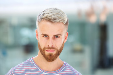 Close up handsome young man with beard staring