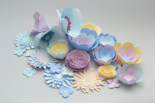 Fototapeta hand made paper flowers in light blue pink and yellow colorful flowers  on a gray background