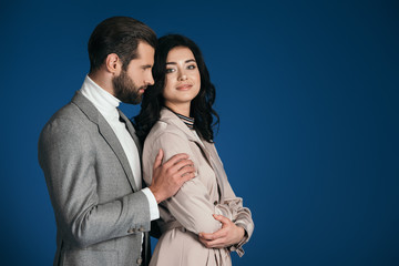 boyfriend hugging girlfriend isolated on blue