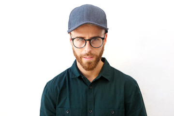 young man with hat and glasses staring