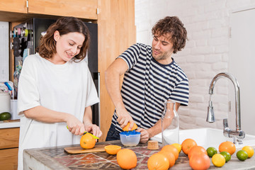happy couple making orange juice