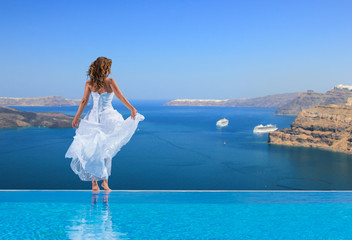 Fototapeta na wymiar Bride standing on the edge on the infinity pool