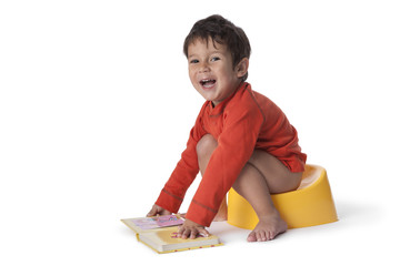 Toddler boy sitting on a potty - obrazy, fototapety, plakaty