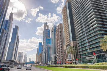 Fototapeta na wymiar DUBAI, UAE - DECEMBER 9, 2016: Downtown Dubai skyscrapers on Zayed Road as seen from a moving car. The city attracts 30 million tourists annually
