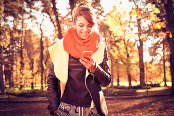 Young woman in the park using smart phone.
