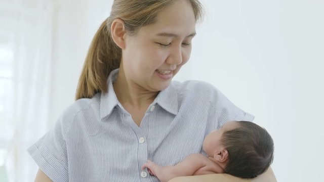 4K Happy Asian mother hugging her newborn baby daughter, Pan shot