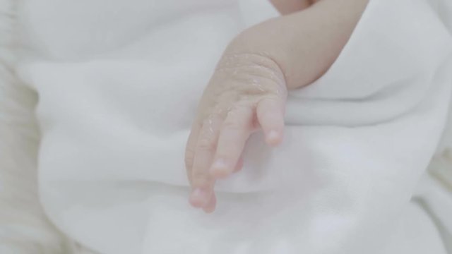 4K Close up hands of Asian  baby laying on a soft blanket