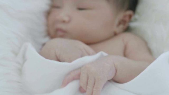 4K Close up of Asian  baby laying on a soft blanket, Slow motion shot
