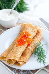 Traditional Russian pancakes with red caviar, selective focus
