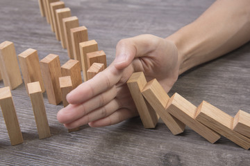 hand stopping wooden block domino. concept prevent and solution. - obrazy, fototapety, plakaty
