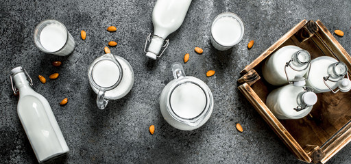 Fresh milk in bottles and jugs with a wooden box.