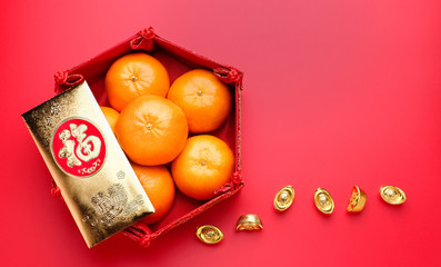 Group of orange tangerine in Chinese pattern tray and golden envelope packet ang pow with gold...