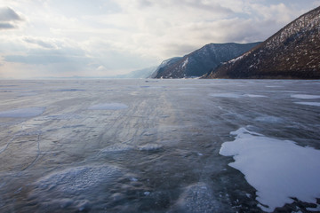 view of lake with ice surface and rocks formations on shore ,russia, lake baikal