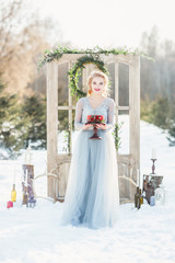 Obraz na płótnie Canvas Bride in a blue wedding dress holding a cake.