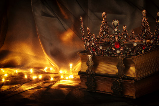 low key image of beautiful queen/king crown on old book. fantasy medieval period.