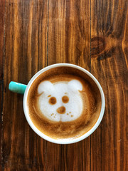 Cute dog face latte art coffee in white cup on wooden table , love dog love coffee, copy space and top view, love your cup, dog cafe