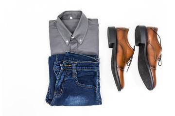 Top view men apparel, grey shirt, blue jean, leather shoes brown.