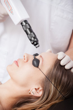 woman during face laser therapy in cosmetics