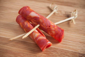 tranches de chorizo en brochettes sur planche à découper en bambou