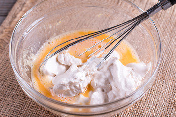 Whipped eggs with cream on a wooden table