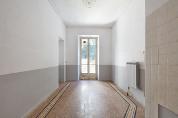 Old, empty room interior with window and tiled floor