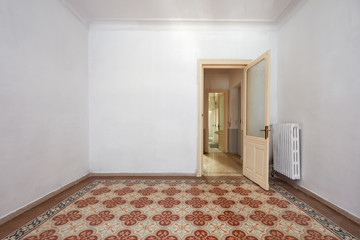 Empty room interior with ancient tiled floor and wooden door