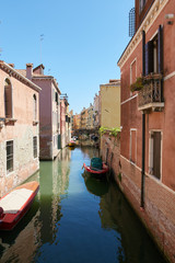 Fototapeta na wymiar Venice, Italy - August 14, 2017: Venice canal with boats and classic buildings.