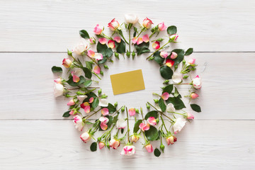 Greeting card in pink natural roses frame on white rustic wood