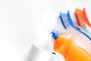 Dishwashing liquid, tableware and brushes on white background to