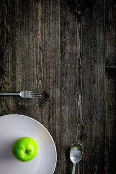 Slimming diet. Apple at plate on wooden background top view copy