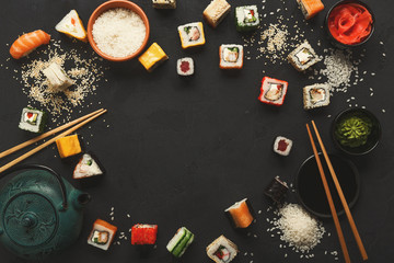 Sushi and rolls background, frame on black, top view.