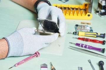 smart phone repair. repairman disassembling smartphone