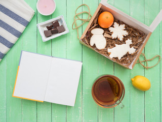 Glass cup of black tea, chocolate and gingerbread gingerbread on a mint-colored table